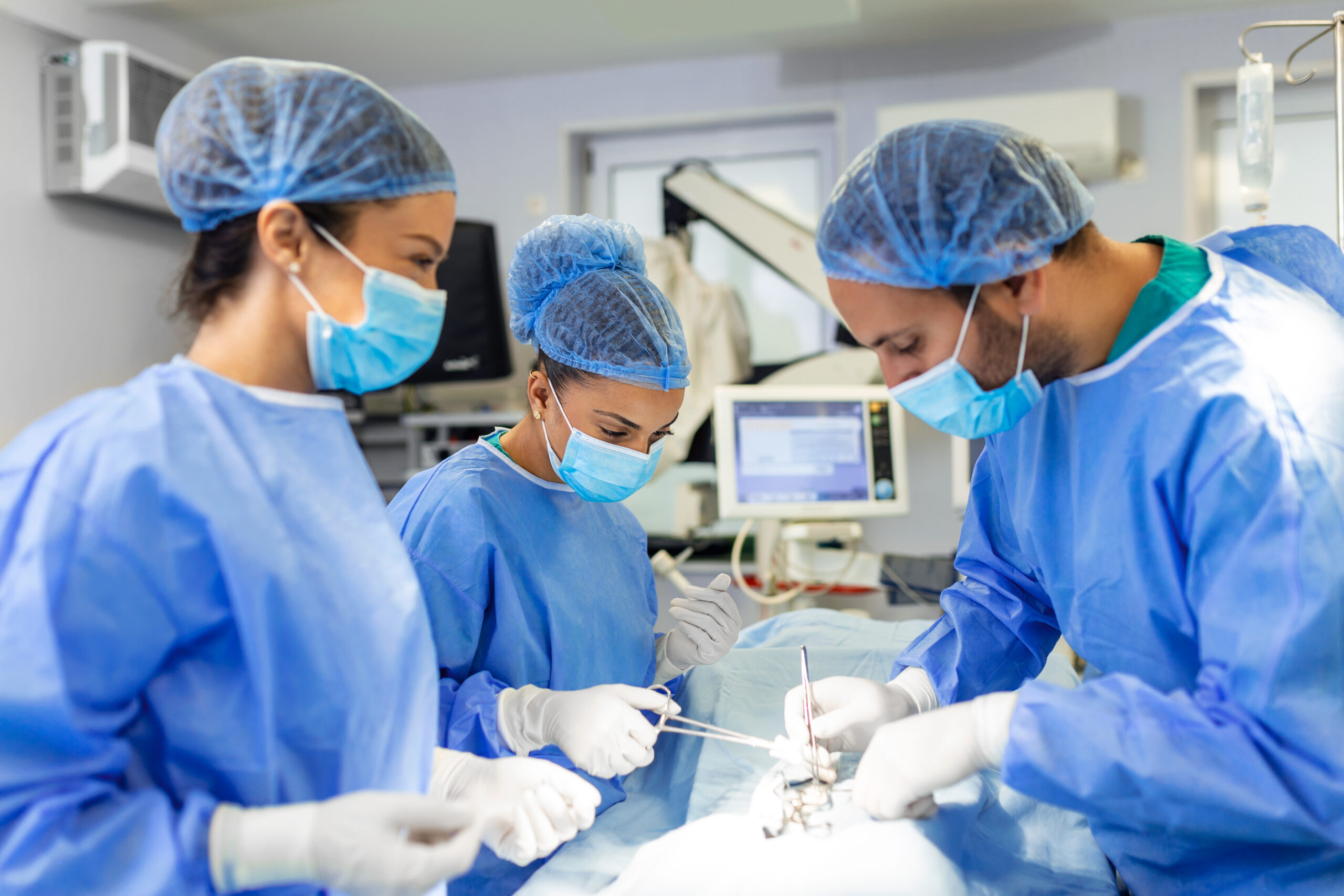 Group of surgeons doing surgery in hospital operating theater. Medical team doing critical operation. Group of surgeons in operating room with surgery equipment. Modern medical background